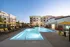 Modern apartment complex with a luxurious outdoor pool and stylish poolside seating area, perfect for relaxation and social gatherings.
