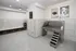 Modern pet wash station with hygienic tiled walls, complete with stainless steel tub and convenient shelving, perfect for pet-friendly living.