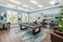 Chic community lounge with a modern pool table, stylish seating, and large windows offering natural light.
