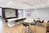 Modern open-concept kitchen and dining area with sleek countertops, elegant bar stools, and stylish wall decor.