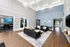 Elegant living area with high ceilings, chic black sofas, and stylish decor, perfect for social gatherings.