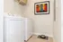 Chic laundry room featuring modern washer and dryer, with stylish artwork and a pet-friendly touch.