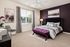 Elegant bedroom featuring a plush bed with geometric patterns, accented by a stylish purple bench and modern decor.