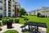 Charming apartment complex with lush green lawns, inviting picnic area, and modern multi-story buildings, perfect for outdoor relaxation.