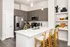 Modern kitchen with chic gray cabinets, sleek stainless steel appliances, and a stylish breakfast bar with woven stools.