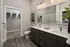 Elegant bathroom featuring a spacious double vanity, modern lighting, and a walk-in closet with ample storage.