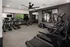 Modern fitness center with treadmills, exercise bikes, and a large TV for an engaging workout experience.