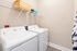 Modern laundry room featuring a sleek washer and dryer set, with convenient overhead shelving for organized storage.