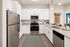 Modern kitchen with stainless steel appliances, sleek white cabinets, and elegant granite countertops, creating a welcoming and sophisticated space.