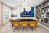 Modern conference room featuring a sleek black table surrounded by stylish mustard chairs, large decorative lighting, and a built-in wall shelf unit.