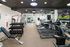 Modern gym with state-of-the-art equipment, including treadmills, weight machines, and free weights, offering a dynamic workout environment.