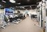 Modern fitness center equipped with state-of-the-art exercise machines, cozy lighting, and large TV screens, perfect for a refreshing workout experience.
