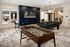 Modern entertainment room featuring a foosball table, pool table, and stylish seating with a sleek TV setup.