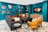 Chic living room with vibrant teal walls, stylish decor, plush gray sectional, and cozy yellow chairs offering an inviting ambience.