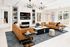 Elegant living room with luxurious leather sofas, modern chandeliers, and a cozy fireplace, offering a perfect blend of comfort and style.