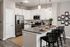 Modern kitchen with sleek granite countertops, stainless steel appliances, and chic pendant lighting, perfect for entertaining.