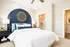 Bright and modern bedroom with a stylish navy accent wall, elegant bed, and spacious walk-in closet.