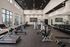 Modern fitness center with state-of-the-art equipment, mirrored walls, and large windows for natural light.