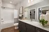 Contemporary bathroom featuring elegant granite countertops, sleek fixtures, and a spacious shower area, exuding modern sophistication.