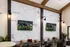 Modern communal lounge featuring large wall map, cozy seating, and dual screens perfect for sports viewing.