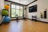 Modern fitness room with stationary bikes, vibrant exercise balls, and kettlebells, featuring natural light and a stylish hardwood floor.