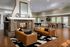 Luxurious open-concept living area featuring a modern fireplace, elegant leather sofas, and a stylish game zone with pool and foosball tables.