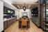 Modern dining space with a sleek wooden table, leather chairs, and a media wall showcasing a large flat-screen TV.