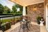Charming patio with elegant black wrought iron furniture, overlooking lush green park views, perfect for serene outdoor dining.
