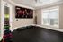 Stylish home gym with sleek flooring, vibrant dumbbells, and a large screen showcasing motivational workouts.