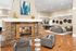 Elegant living room with a cozy stone fireplace, stylish gray furniture, and modern art accents, offering a warm and inviting ambiance.
