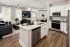 Kitchen with white cabinets and granite island at Abberly Commons in Charlotte, NC.