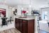 Contemporary apartment interior showcasing an open-plan kitchen with elegant granite countertops and stylish wooden cabinetry, dining area with modern decor, and bright living space with balcony access.
