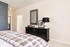 Contemporary bedroom with stylish plaid bedding, sleek black dresser, and chic decor.