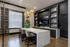 Elegant modern kitchen featuring a large marble island, stylish pendant lighting, and built-in shelving with decorative accents.