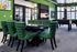 Inviting recreation room featuring vibrant green decor, a large TV, stylish seating, modern game table, and panoramic windows.