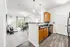 Bright and modern open-concept apartment kitchen and living area with sleek appliances, light-filled windows, and elegant decor.