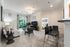 Elegant living room with cozy seating, sleek decor, and natural light from large windows, adjacent to a stylish open kitchen and a glimpse of a modern bedroom.
