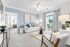 Bright and modern living room with blue accents, comfortable seating, elegant decor, and a balcony view.