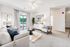 Bright and inviting modern living room with elegant furniture, plush carpeting, and large glass doors opening to a serene balcony view.