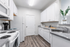 Modern kitchen with sleek white cabinetry, gleaming countertops, and elegant flooring creating a spacious and inviting atmosphere.