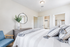 Bright and inviting bedroom with a modern touch, featuring a large mirror, elegant decor, and plenty of natural light.