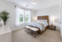 Bright and inviting bedroom featuring a cozy bed with elegant linens and chic decor, enhanced by natural light from large windows.