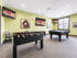 Chic game room featuring a foosball table, pool table, and multiple wall-mounted TVs, perfect for entertainment and relaxation.