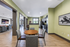 Modern apartment interior featuring an inviting dining area with stylish table, plush seating, and a sleek kitchen with rich cabinetry, leading to a comfortable lounge space with large windows and natural light.