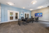 Modern conference room featuring sleek furniture, double glass doors, and a large flat-screen TV for presentations.