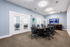 Modern conference room with stylish seating, sleek table, and large TV, perfect for meetings.