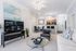 Inviting modern living room with cozy seating, sleek TV setup, and a stylish open kitchen bar area perfect for entertainment.