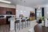 Modern open-concept kitchen and living room with elegant wood cabinetry, sleek granite countertops, and stylish bar stools under pendant lighting. Cozy seating area and media center create an inviting space for relaxation and entertainment.
