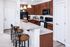 Modern kitchen with sleek granite countertops, rich wooden cabinets, and stylish bar seating.