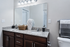 Modern bathroom with elegant granite countertop, double sinks, and stylish decor featuring sleek lighting and plush towels.